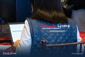 Miembro del equipo de Events Group de espaldas trabajando con una chaqueta con nuestro logo institucional